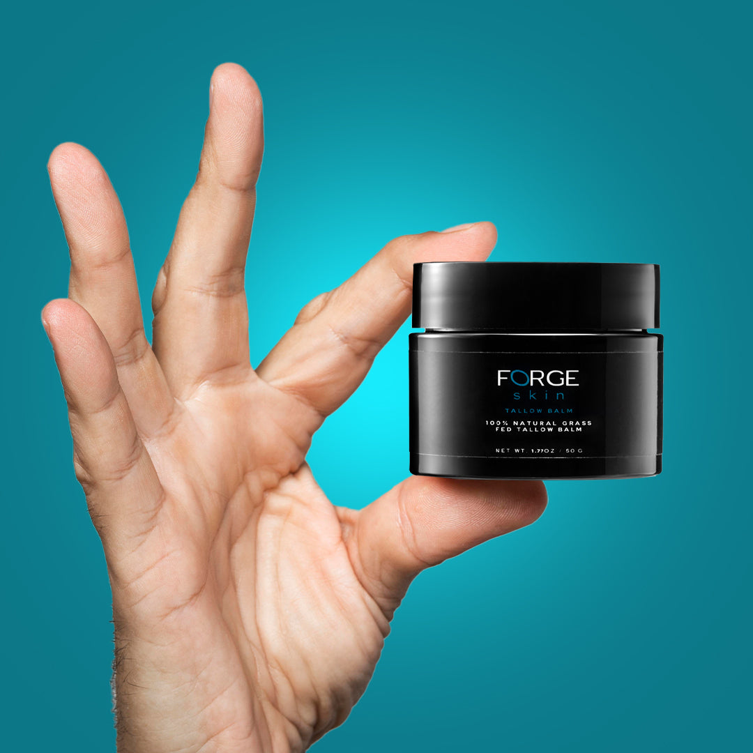 Hand holding a jar of Forge for Men styling balm against a grey background.